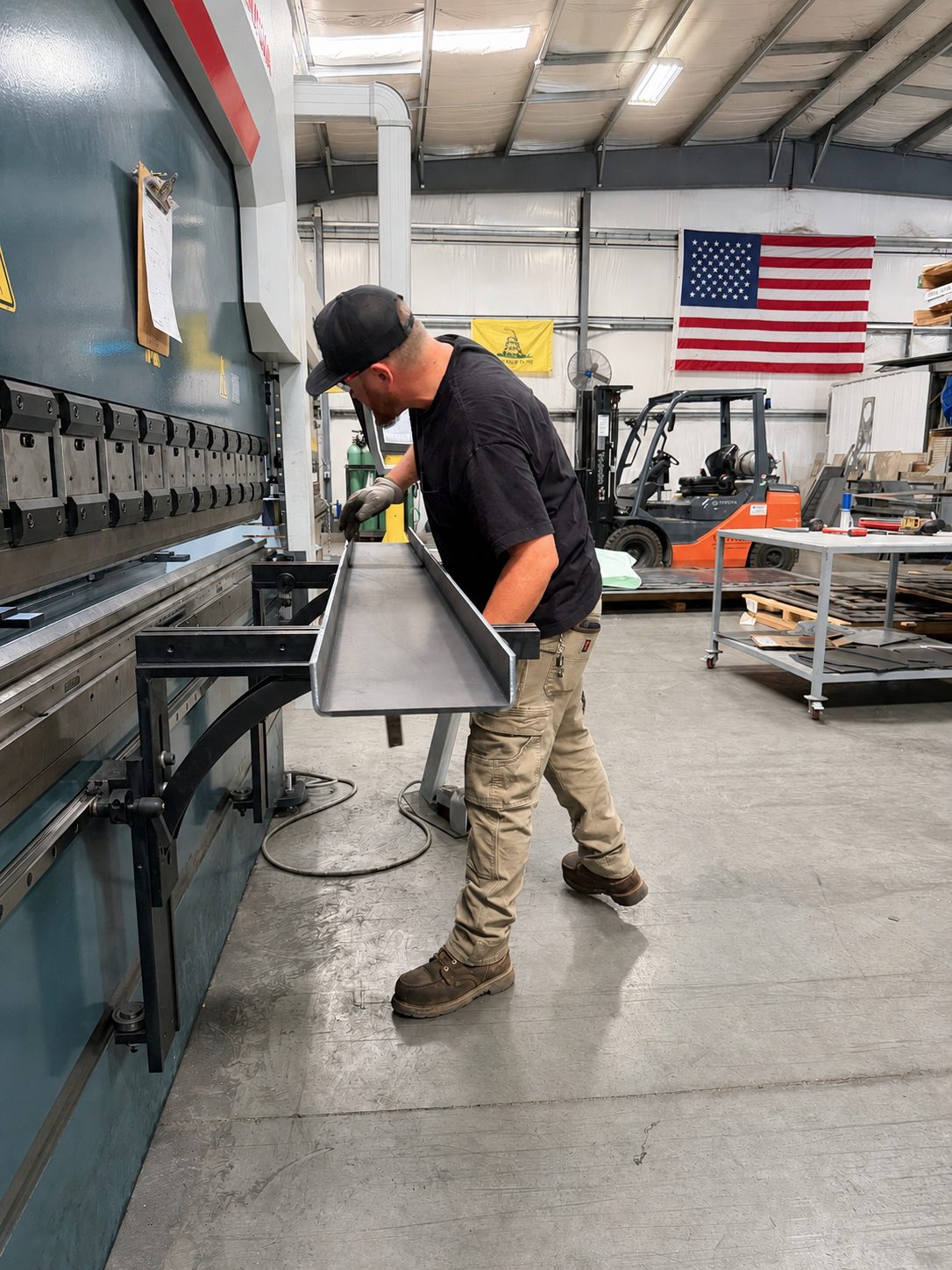 Victory fabricator lifting a formed steel channel off the press brake