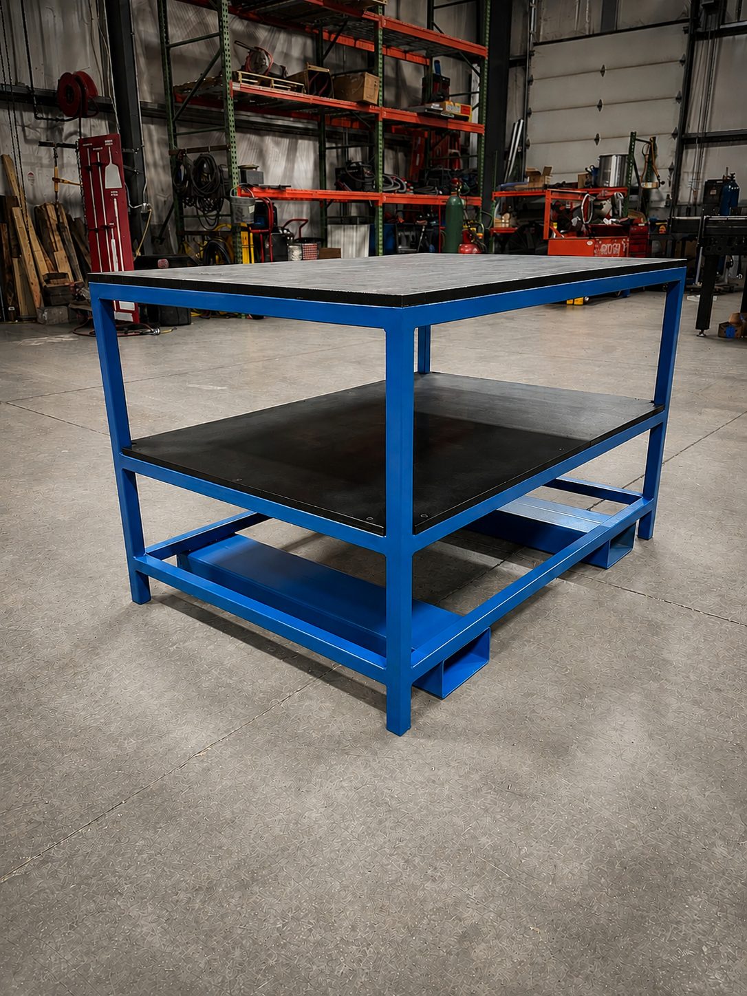 Blue painted steel workbench with a dark work surface and lower shelf